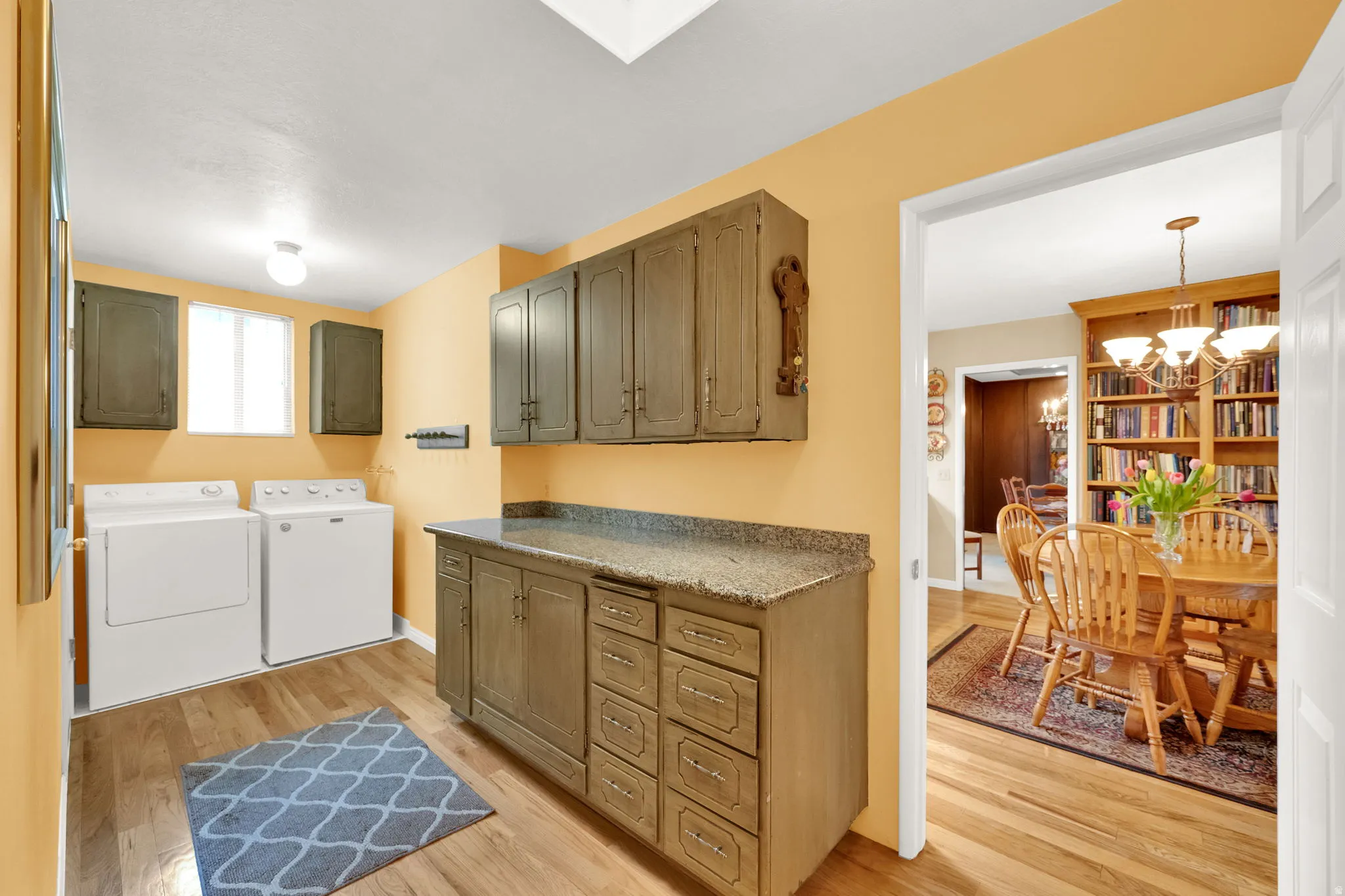 Utility room featuring wood-finish flooring and multiple built-in cabinets