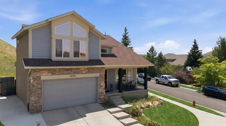 Two-story residence featuring a stone-clad garage and siding exterior