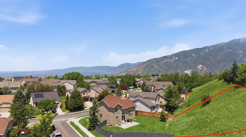 Expansive residential lot featuring a sloped, grassy terrain