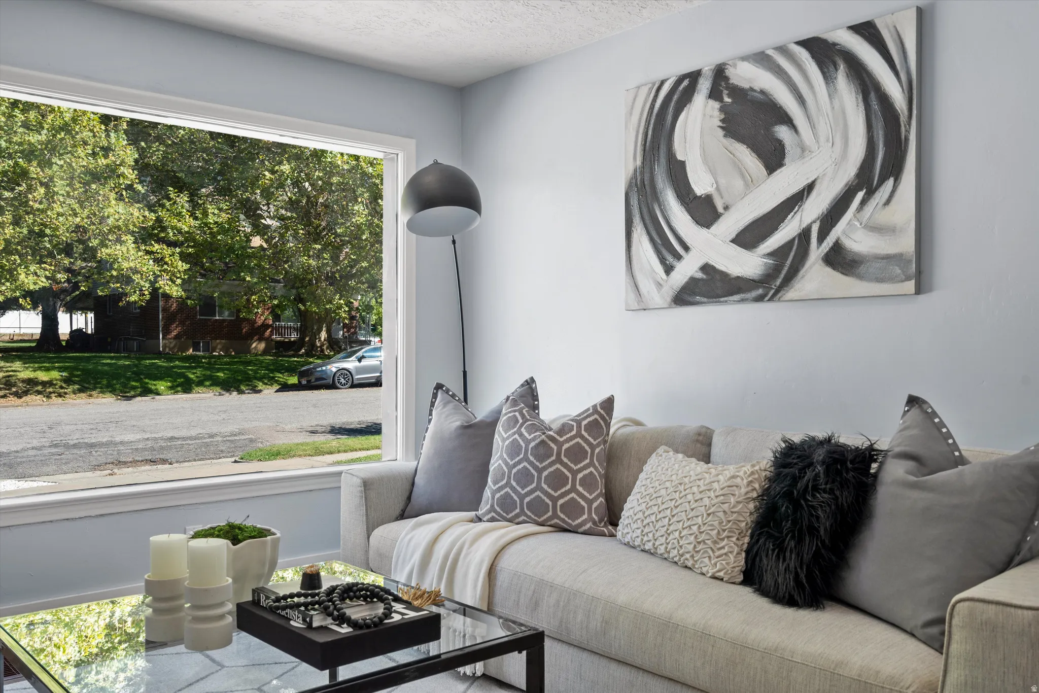 Bright living area featuring a large picture window with white trim