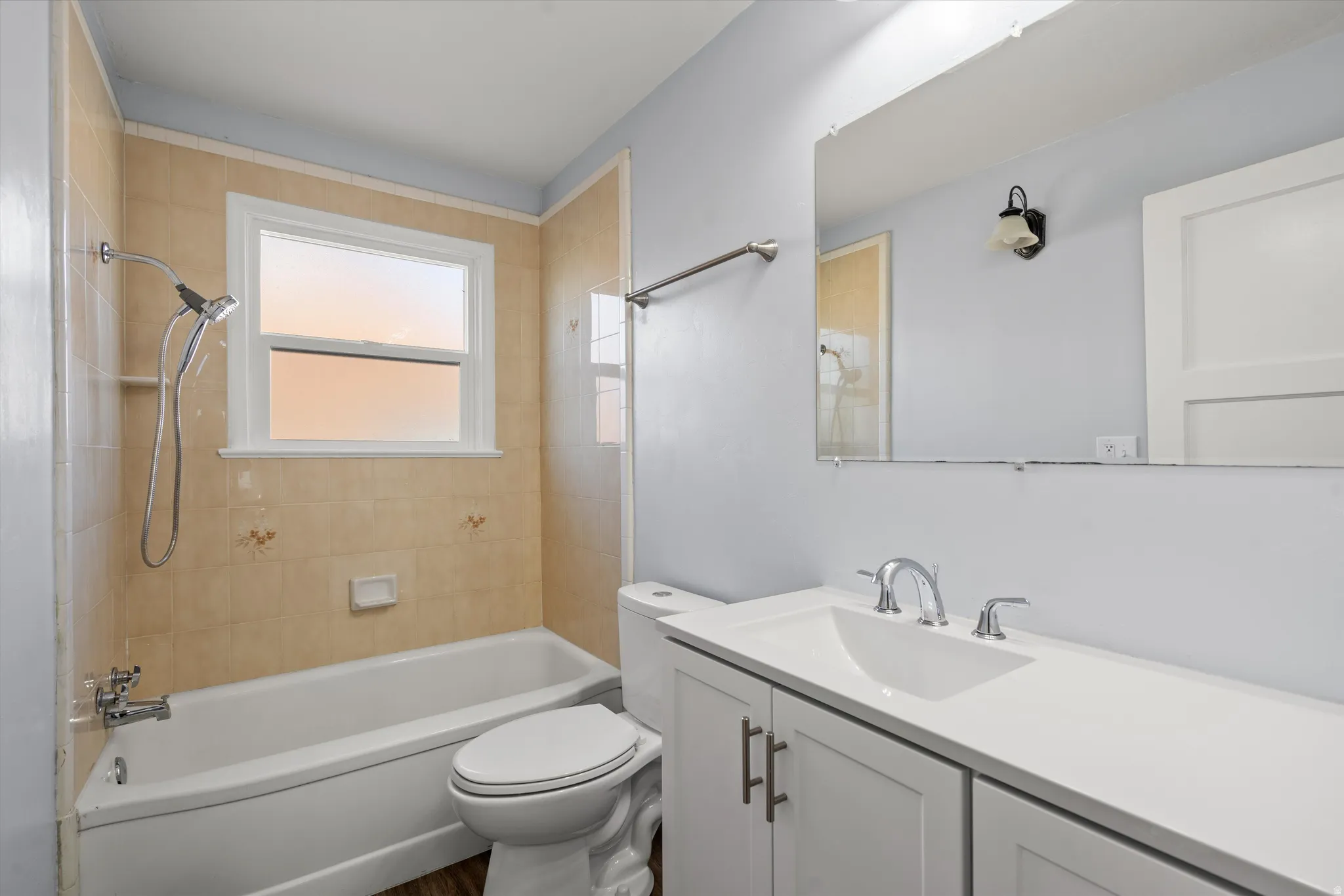 Bathroom featuring a white vanity with shaker-style cabinetry, a built-in sink, and chrome fixtures
