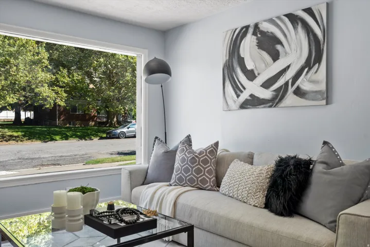 Bright living area featuring a large picture window with white trim