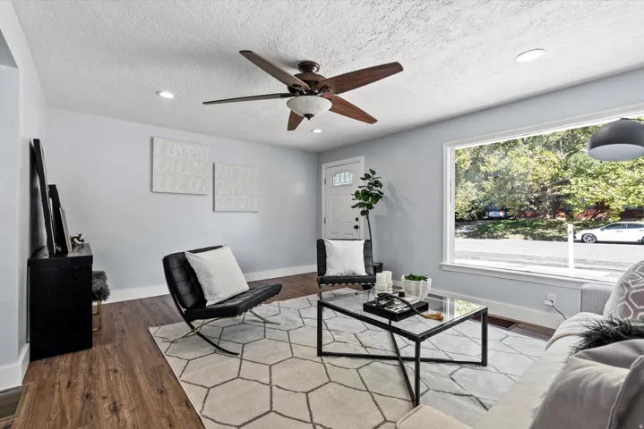 Bright living area featuring wood-finish flooring, recessed lighting, and a prominent picture window