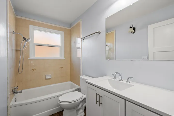 Bathroom featuring a white vanity with shaker-style cabinetry, a built-in sink, and chrome fixtures