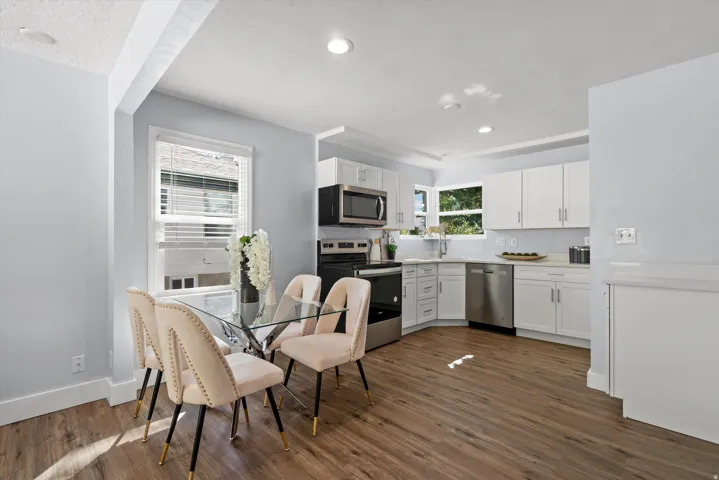Open-concept kitchen and dining area featuring wood-finish flooring
