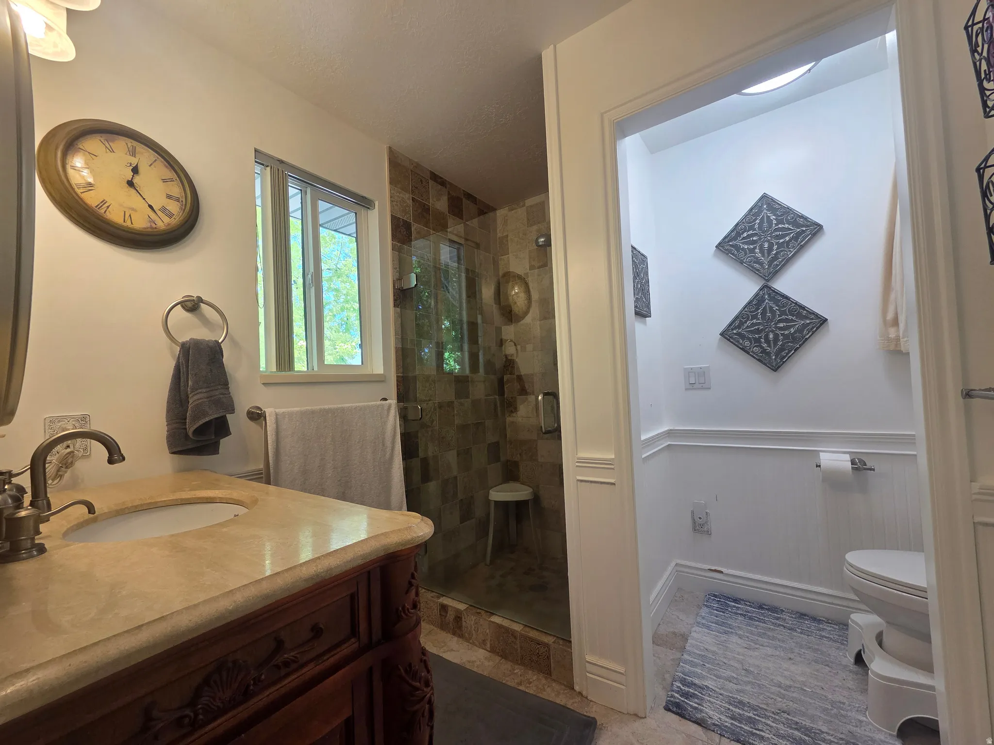 Bathroom featuring a carved wood vanity with a stone countertop and integrated sink