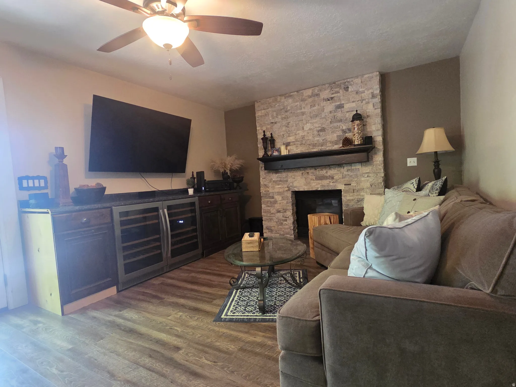 Living area featuring a stone accent wall with a fireplace and wood mantel