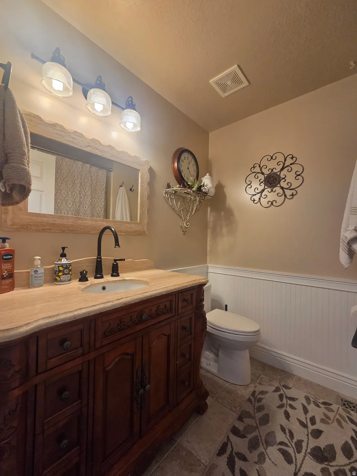 Ornate wood vanity with a solid surface countertop and undermount sink