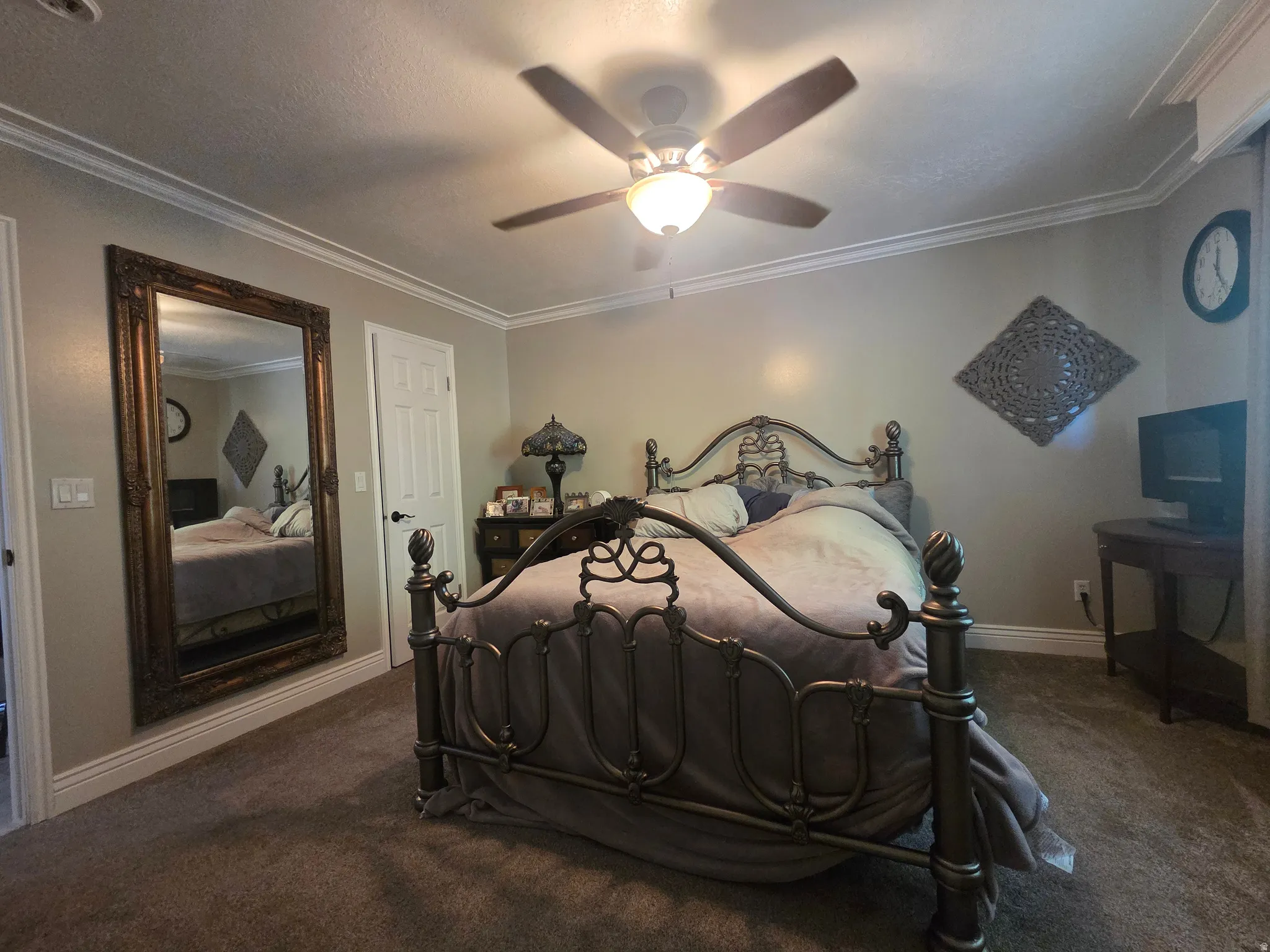 Carpeted room featuring crown molding and a ceiling fan with integrated lighting