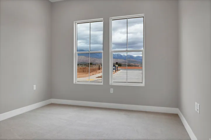 Bright interior space featuring two large windows, neutral gray wall paint, white trim, and light gray carpeting