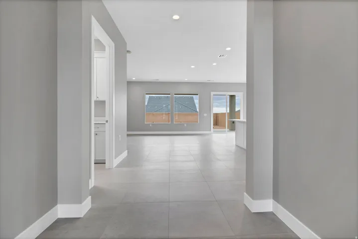 Open-concept living space featuring large format floor tiles, recessed lighting, and expansive windows