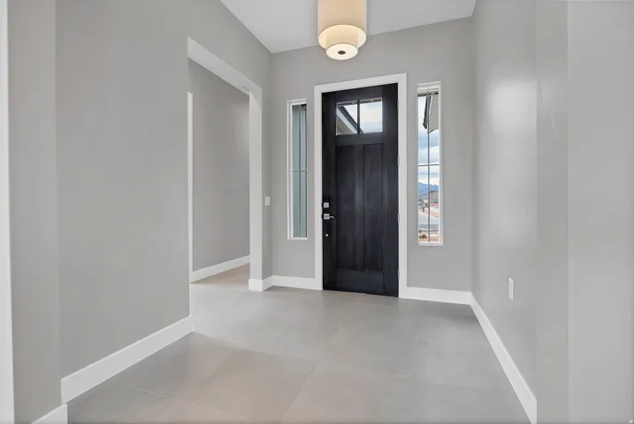 Entryway featuring a dark paneled door with glass inserts, two vertical side windows, and a flush mount ceiling light