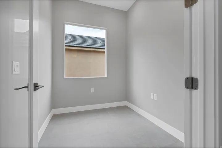 Neutral gray walls with white baseboards and gray tile flooring