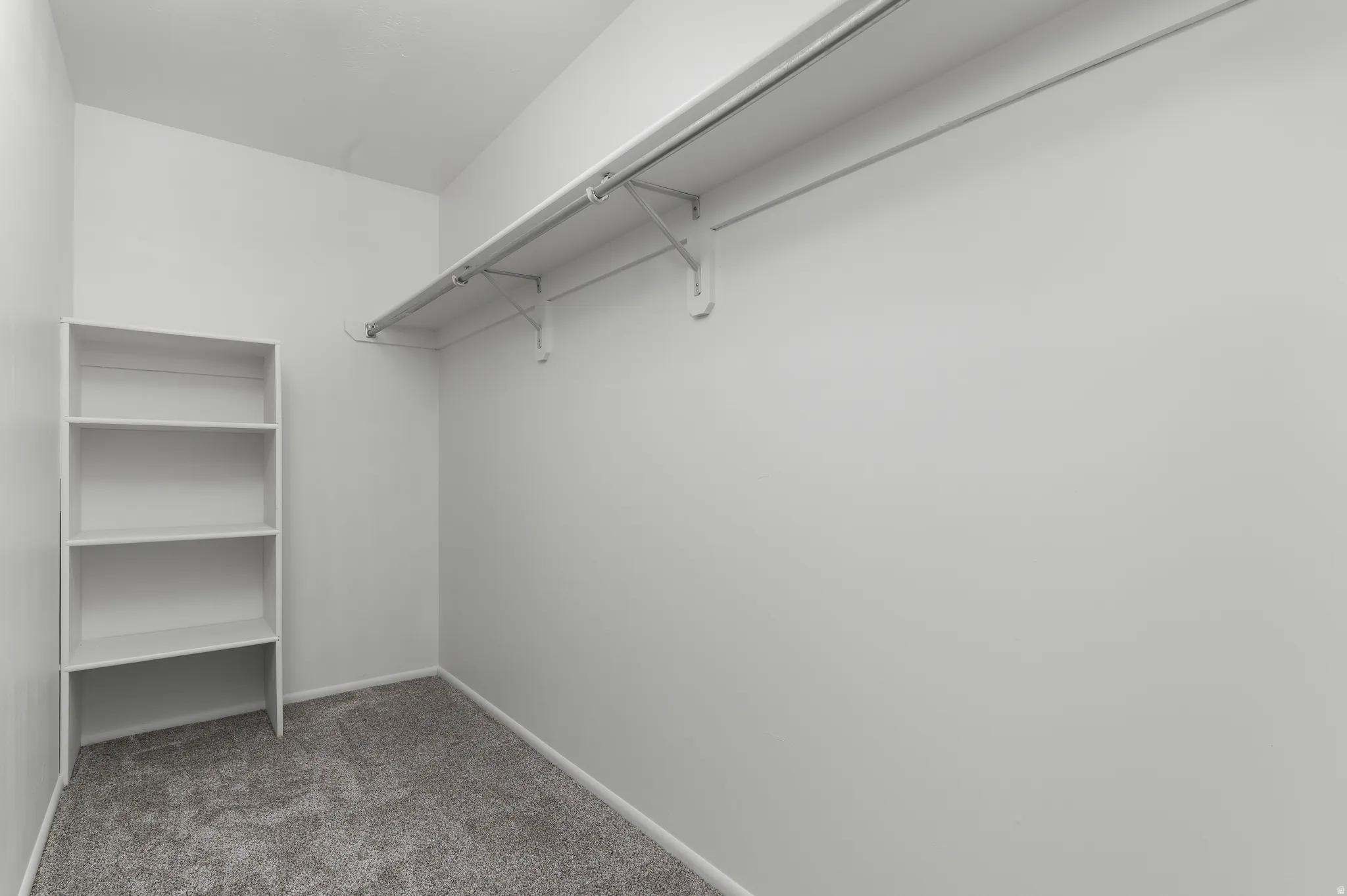 Walk-in closet off of bedroom with brand new carpet and built in shelving