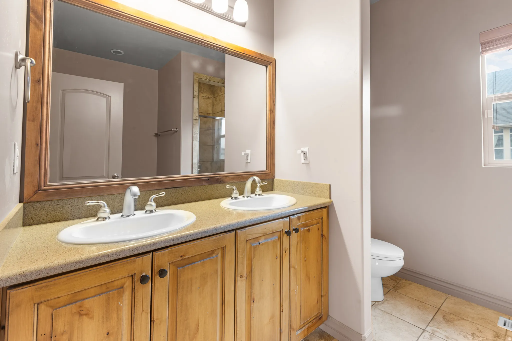 Double vanity featuring two undermount sinks, chrome fixtures, and a light-toned countertop