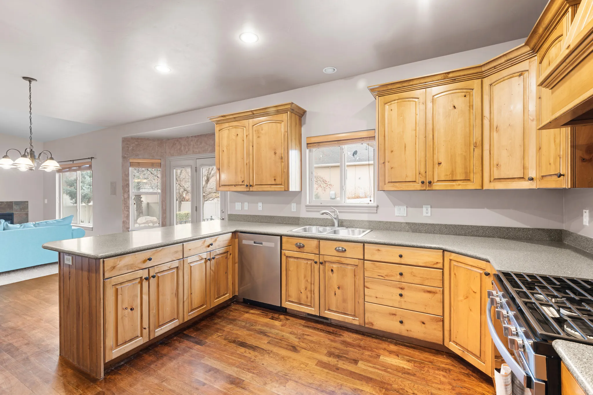 Kitchen featuring wood-finish cabinetry, stainless steel appliances, and L-shaped counters