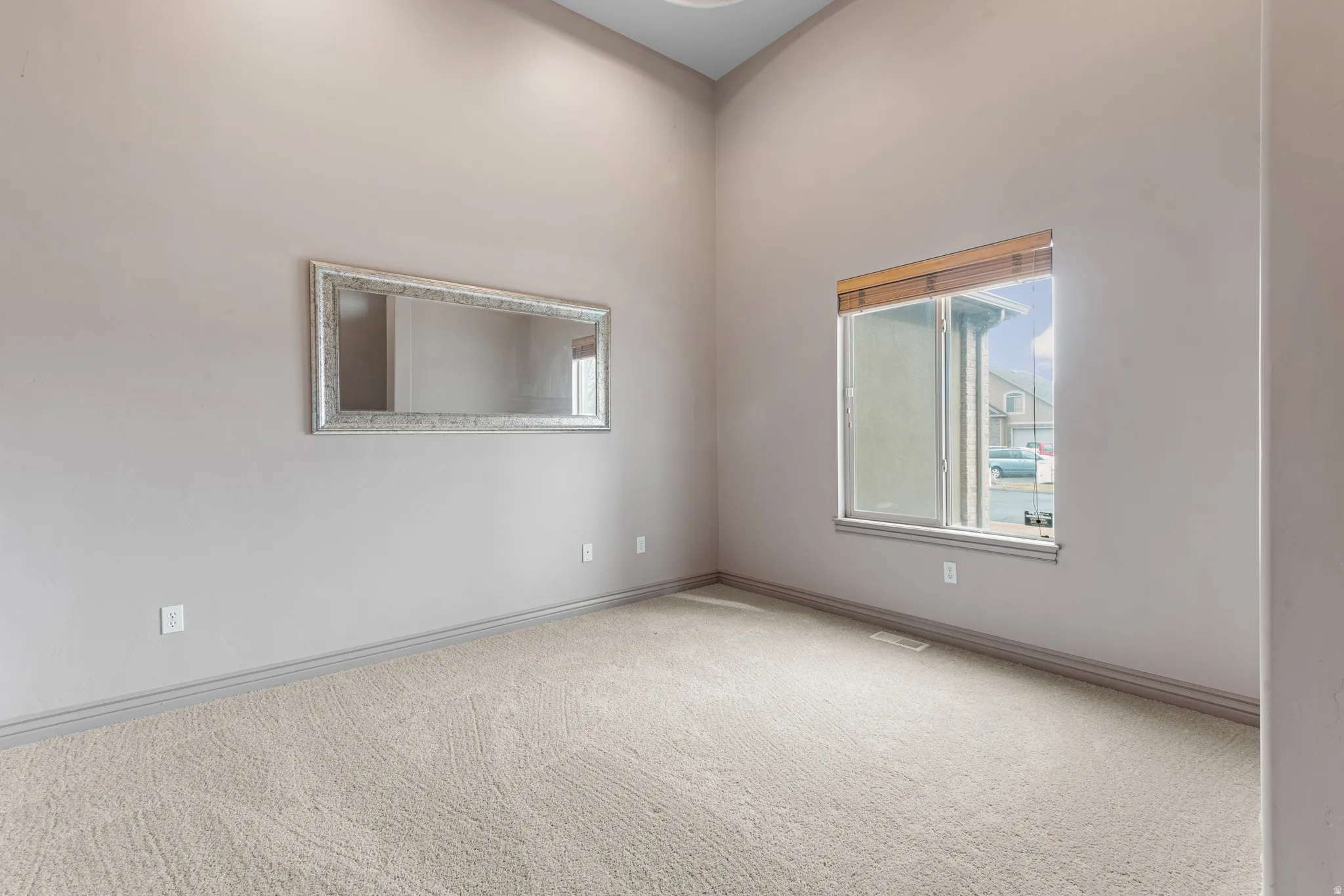 Room featuring vaulted ceilings and neutral wall paint