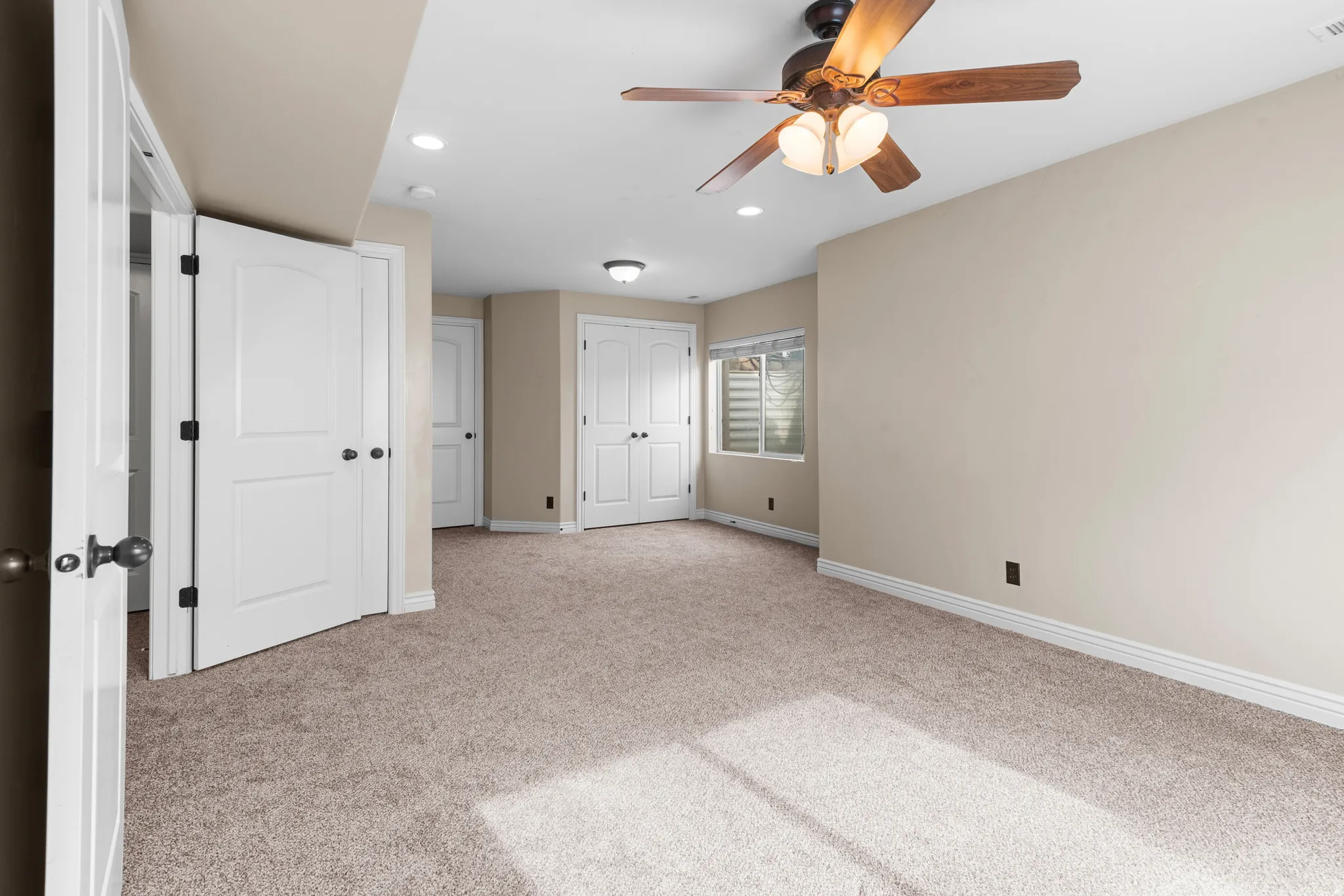 Room featuring carpet flooring, neutral-toned walls, and a ceiling fan with integrated lighting
