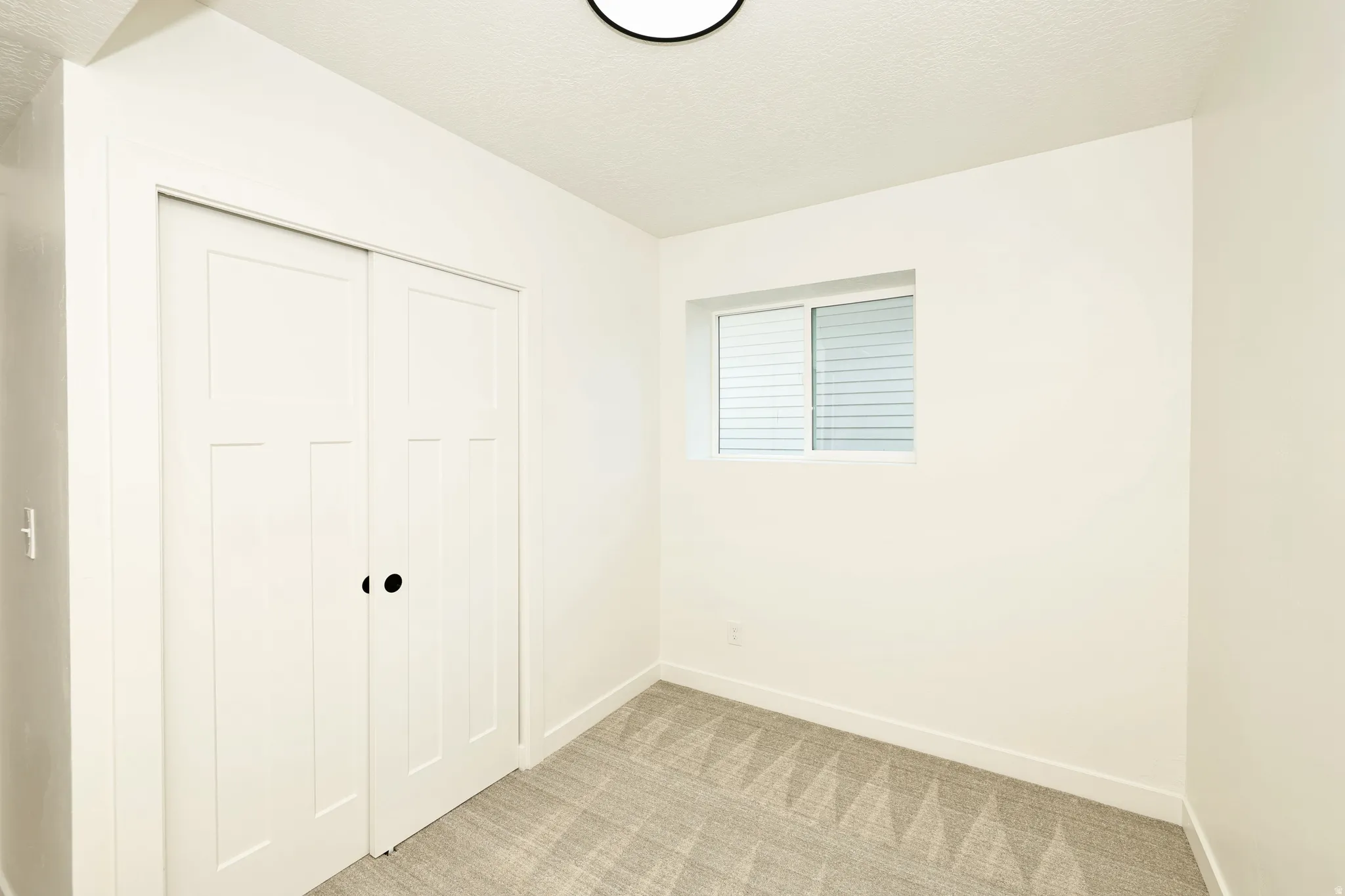 Compact interior space featuring light-colored walls and patterned carpeting
