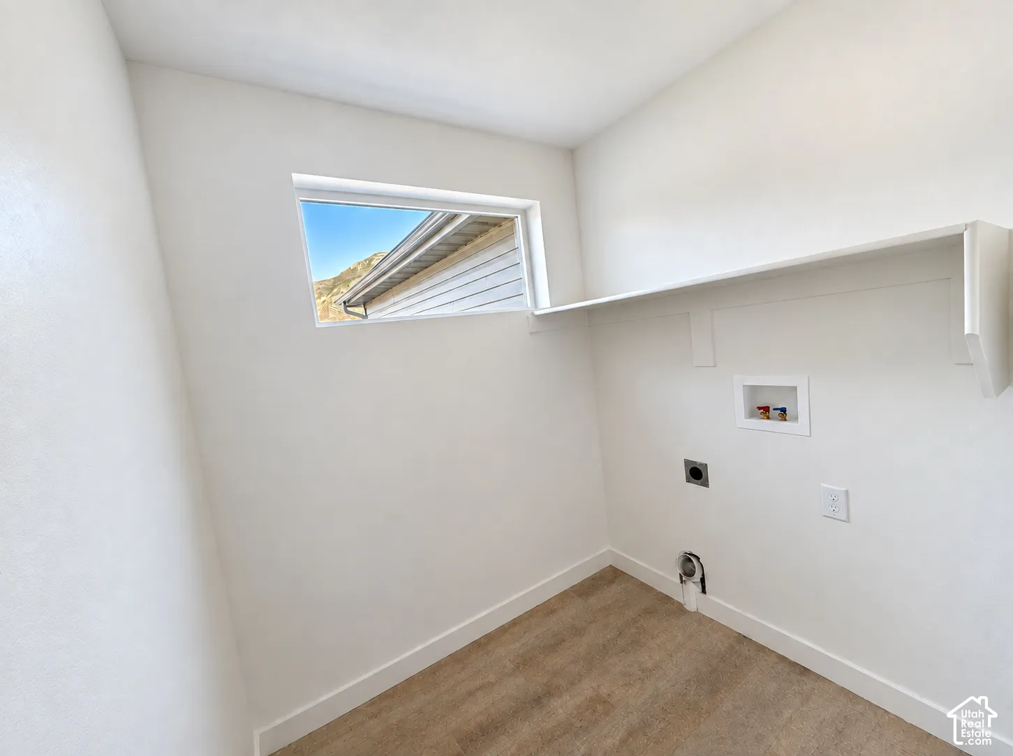 Laundry area featuring a window, built-in shelving, and hookups for appliances