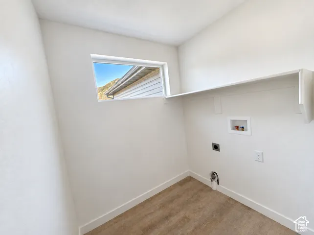 Laundry area featuring a window, built-in shelving, and hookups for appliances