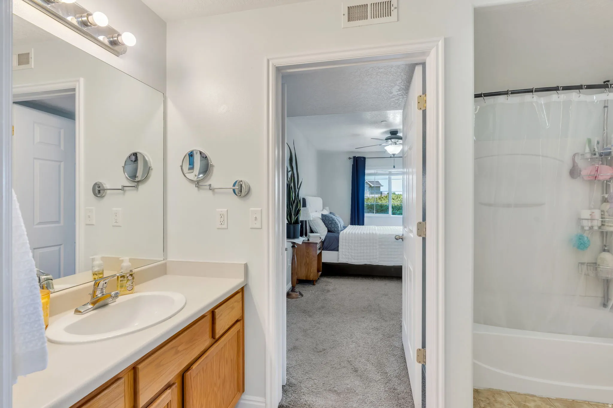 Bathroom vanity featuring a single sink, light-toned countertop, and wood-finish cabinetry