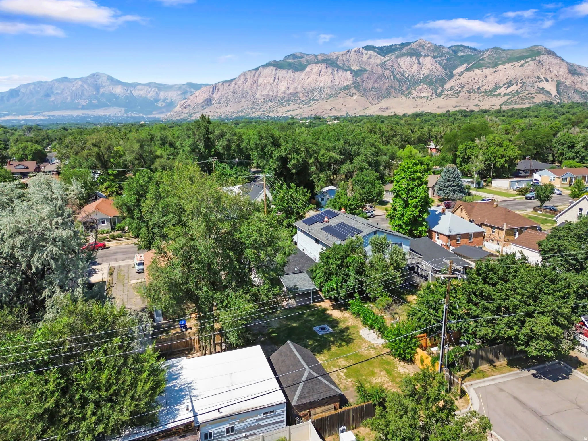 Expansive mountain backdrop framing a residential neighborhood with mature trees