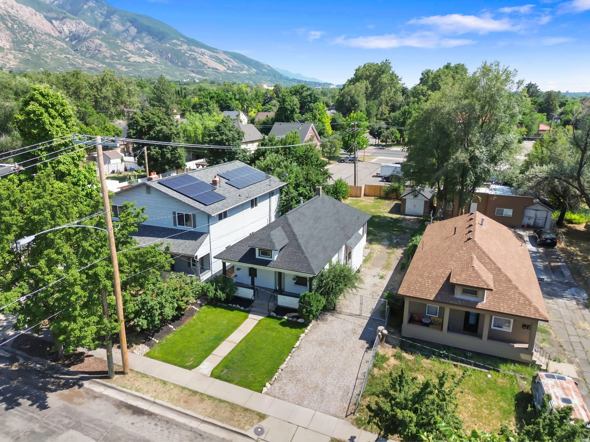 Aerial perspective showcasing a residential property with a neatly maintained front lawn and a paved driveway