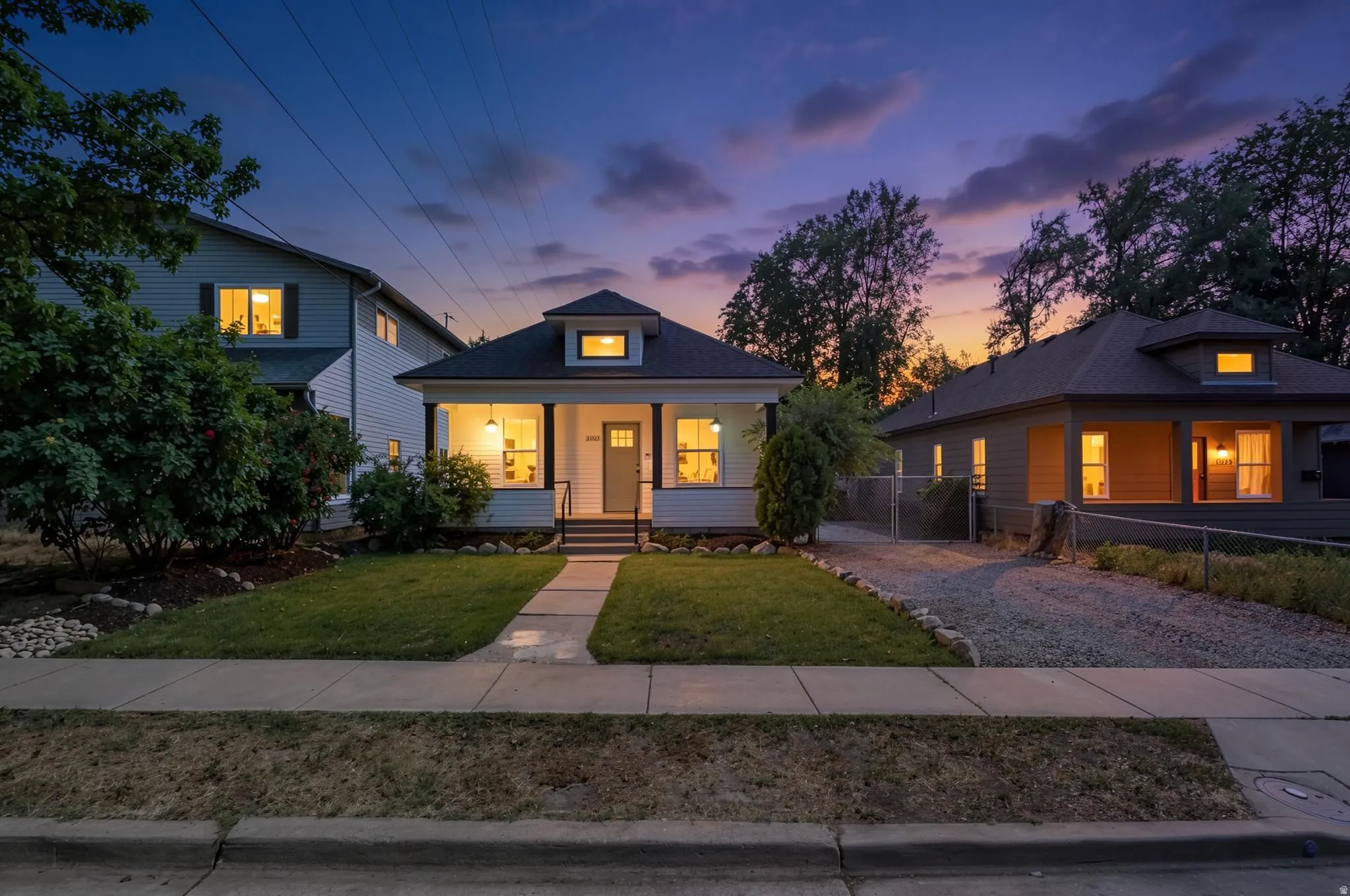 Craftsman-style home featuring a covered front porch with white columns, a dormer window, and a gray front door