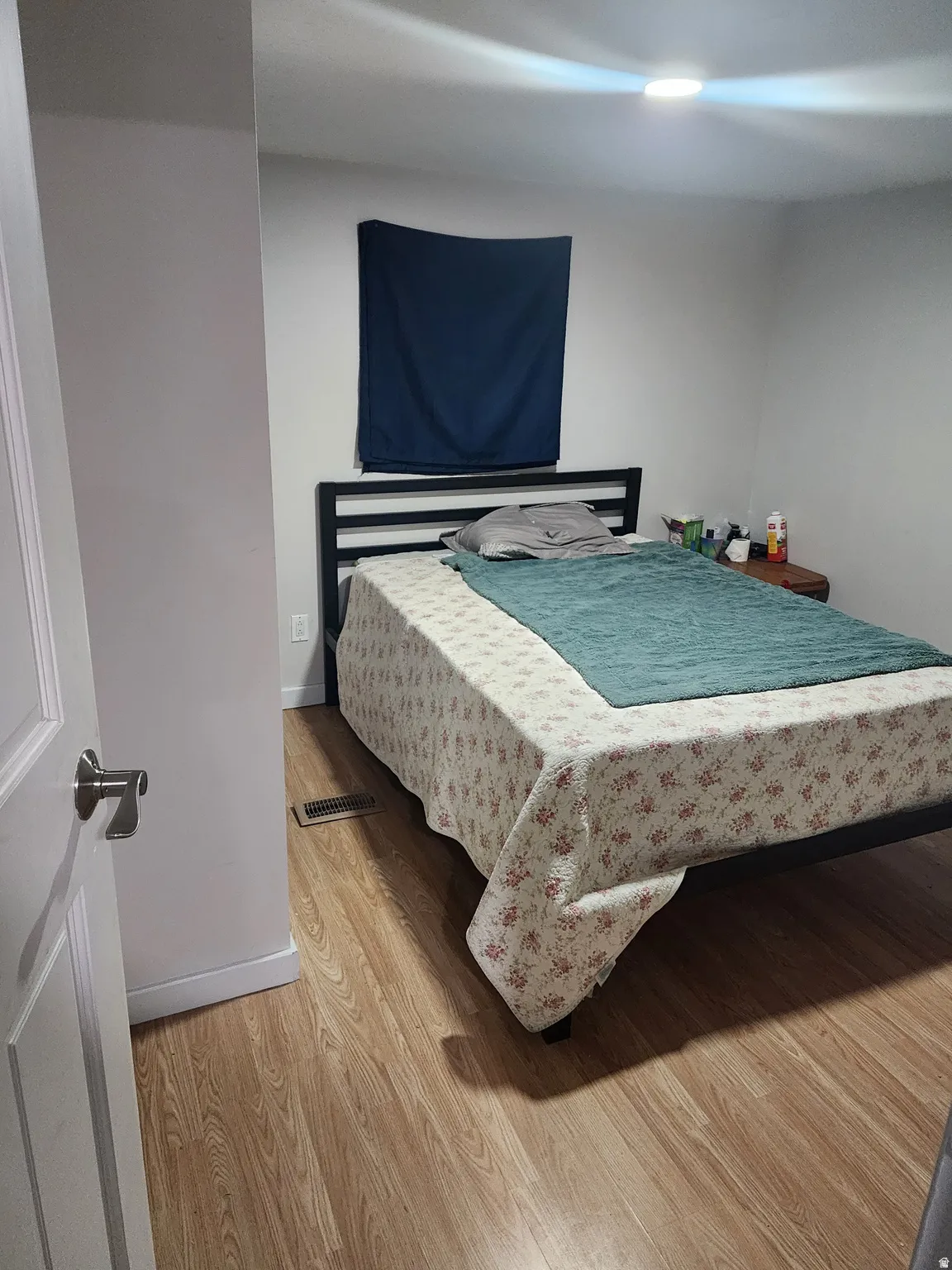 Room featuring wood-finish flooring, white walls, and a recessed ceiling light