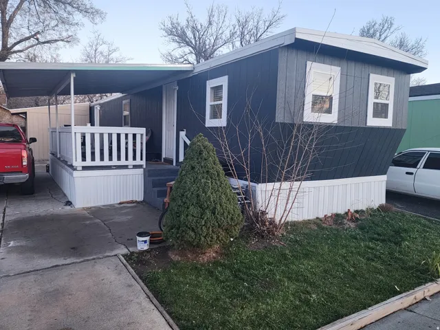 Manufactured home featuring dark gray siding and white trim