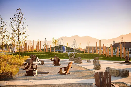 Outdoor gathering space featuring Adirondack chairs, a gravel ground surface, and large natural stone elements