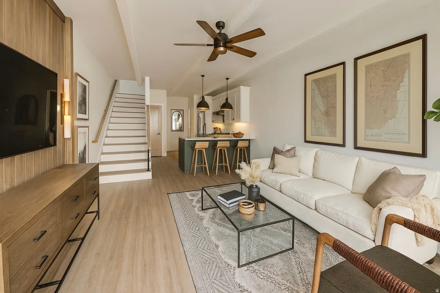 Open-concept living area featuring light wood-finish flooring, a contemporary ceiling fan, and a wood-paneled accent wall with integrated wall sconces