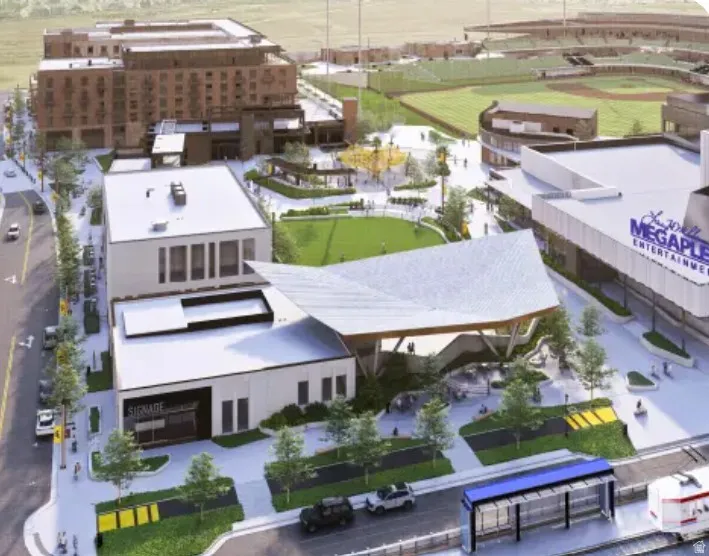 Modern commercial development featuring a central green space, various retail storefronts, and multi-story residential buildings