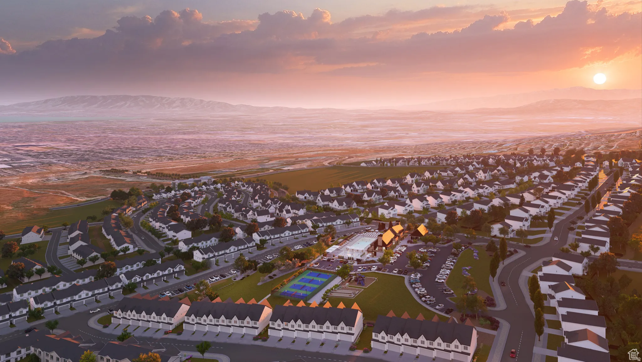 Expansive community featuring residential homes and townhouses, mountains as a prominent backdrop, and a central amenity area