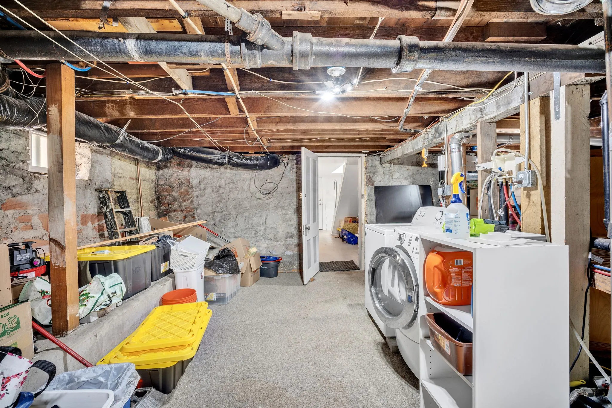 2-bedroom floorplan (614) basement utility area featuring a washer and dryer and extra storage space.