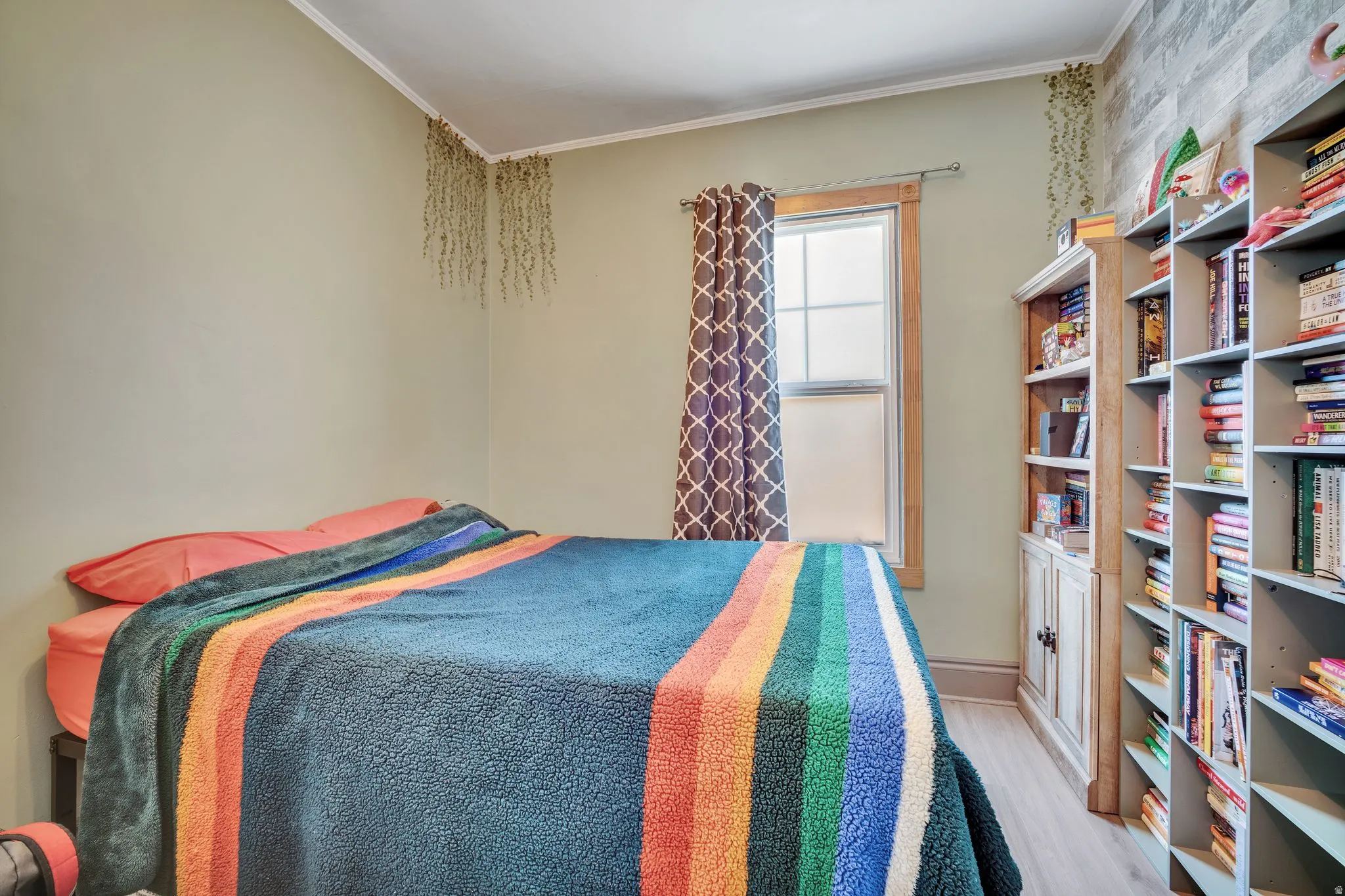 1 bedroom floorplan (618) featuring light-toned walls, wood-finish flooring, a double-hung window with natural wood trim, and built-in shelving