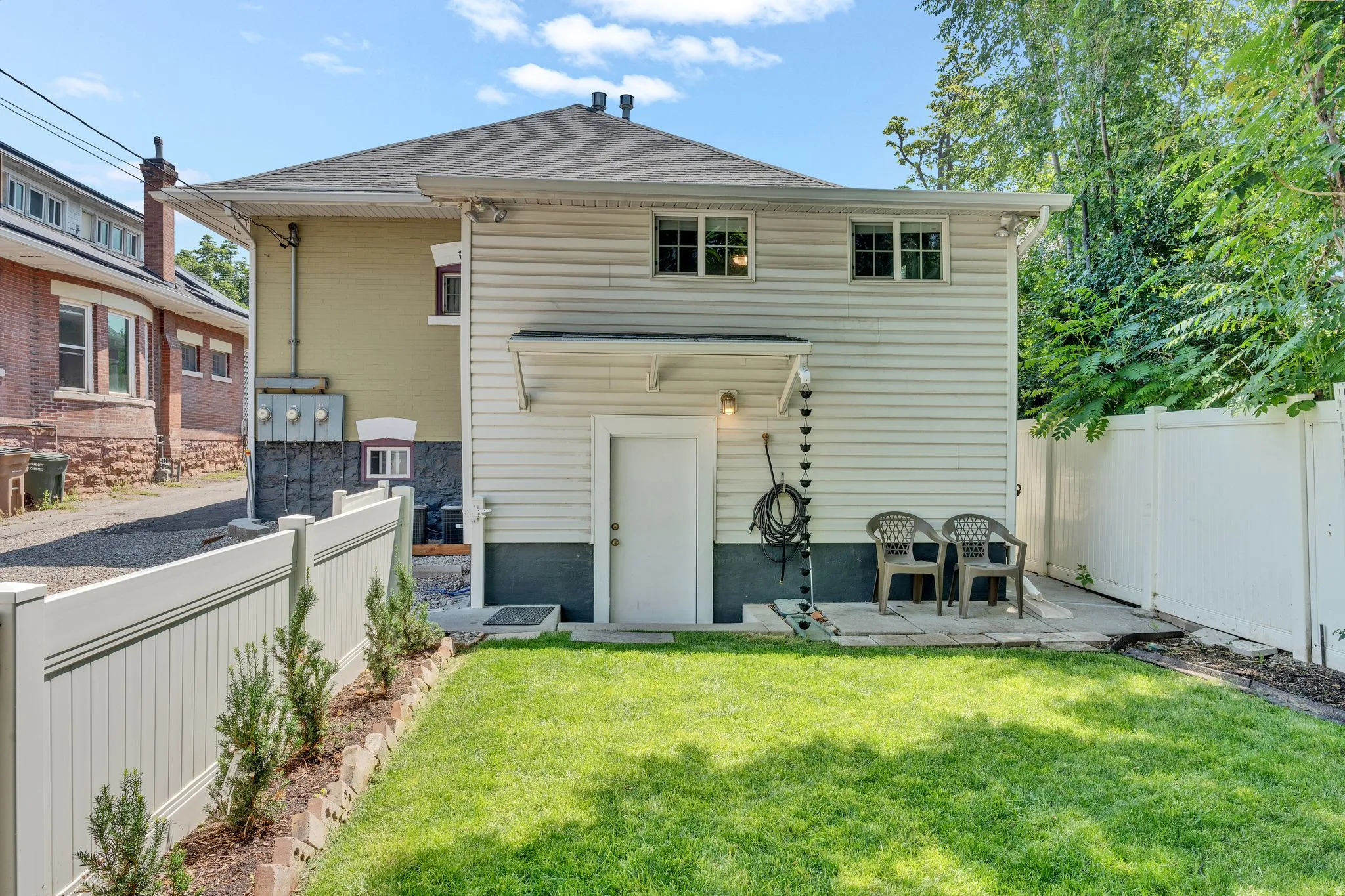 Rear exterior with light-colored siding and a basement walk-out from the 2-bedroom floorplan (614).