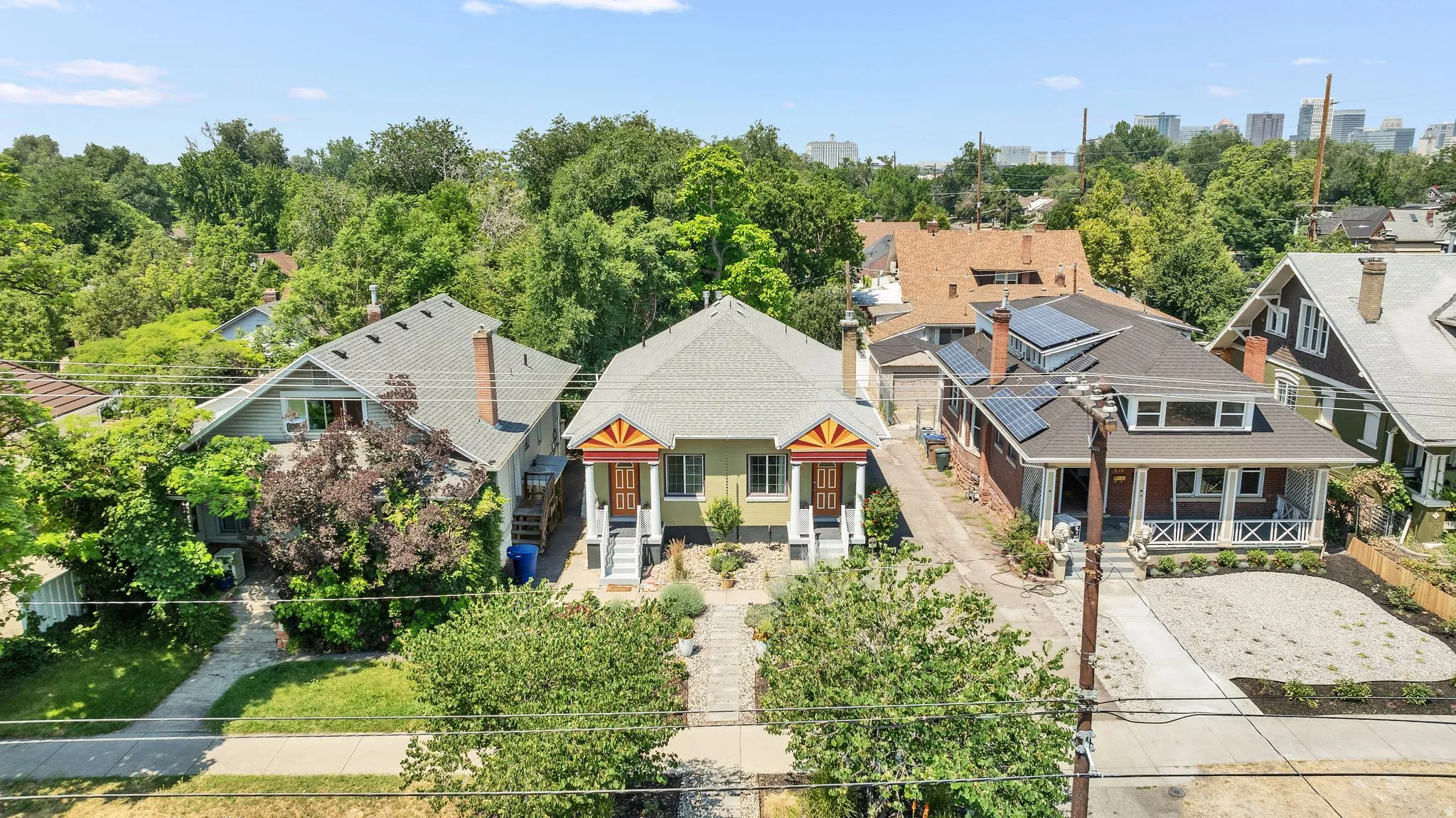 Duplex property featuring two distinct entrances with covered porches, a light green exterior, and gabled roofs