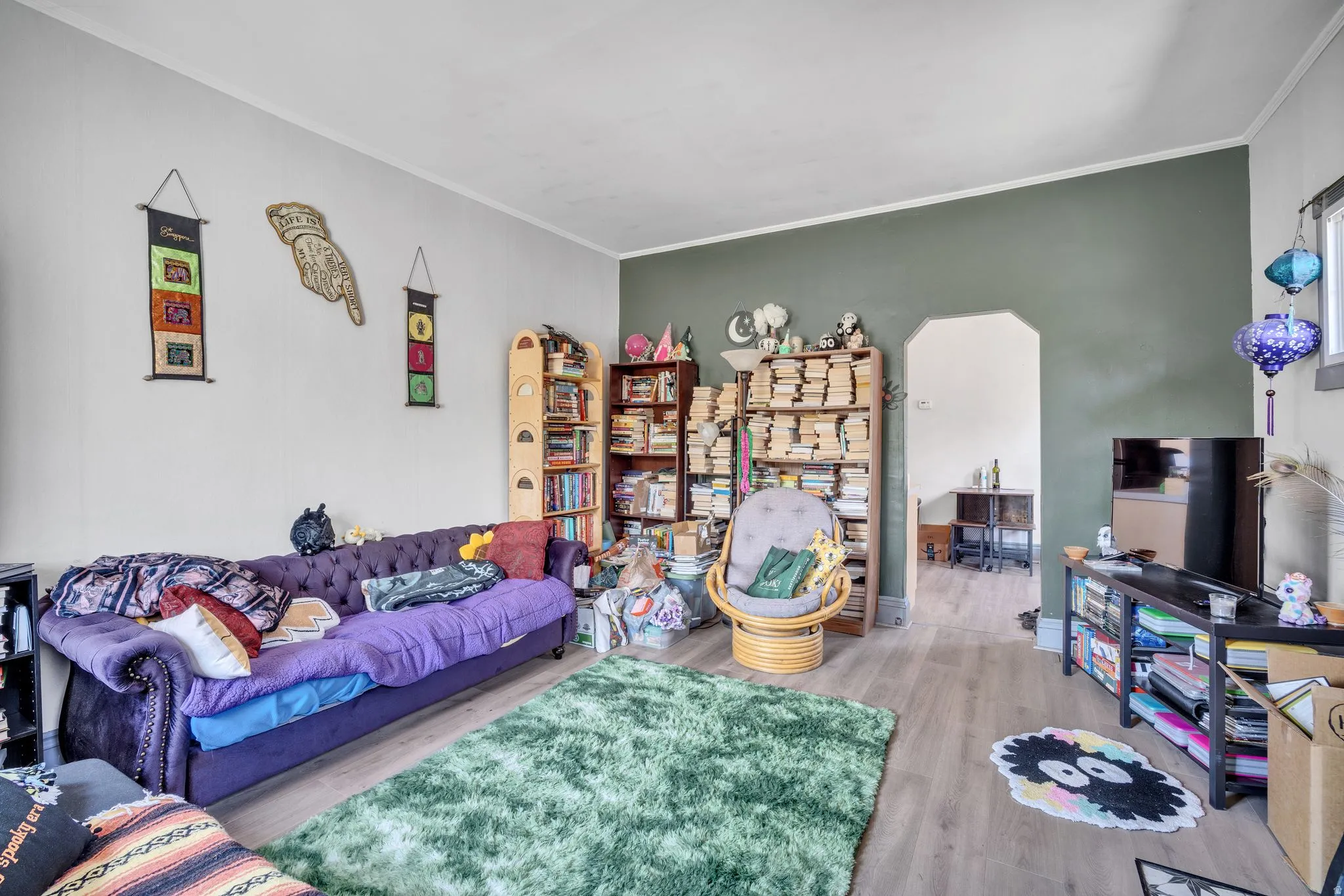 1 bedroom floorplan (618) living area with wood-finish flooring, two-tone wall paint, and an arched doorway