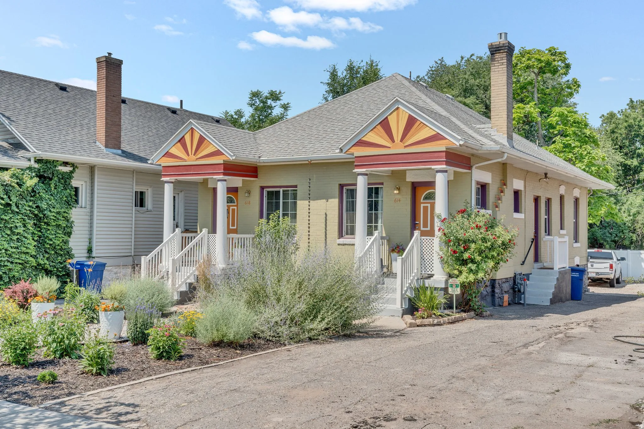Duplex property featuring two distinct entrances with covered porches, decorative gable accents, and brick chimneys