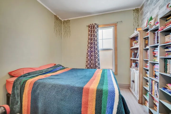 1 bedroom floorplan (618) featuring light-toned walls, wood-finish flooring, a double-hung window with natural wood trim, and built-in shelving
