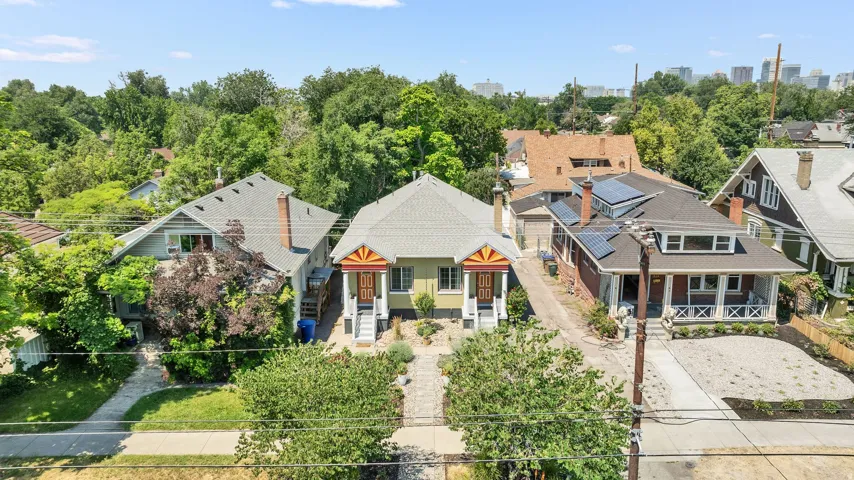 Duplex property featuring two distinct entrances with covered porches, a light green exterior, and gabled roofs