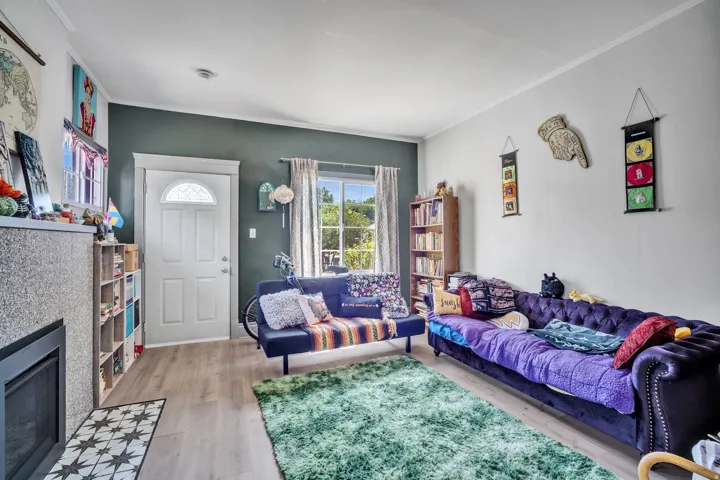 1 bedroom floorplan (618) living area featuring wood-finish flooring, a fireplace with a decorative tile hearth, and a window providing natural light
