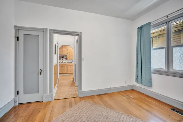 2-bedroom floorplan (614) bedroom #2 with hallway into kitchen.  Featuring hardwood flooring throughout