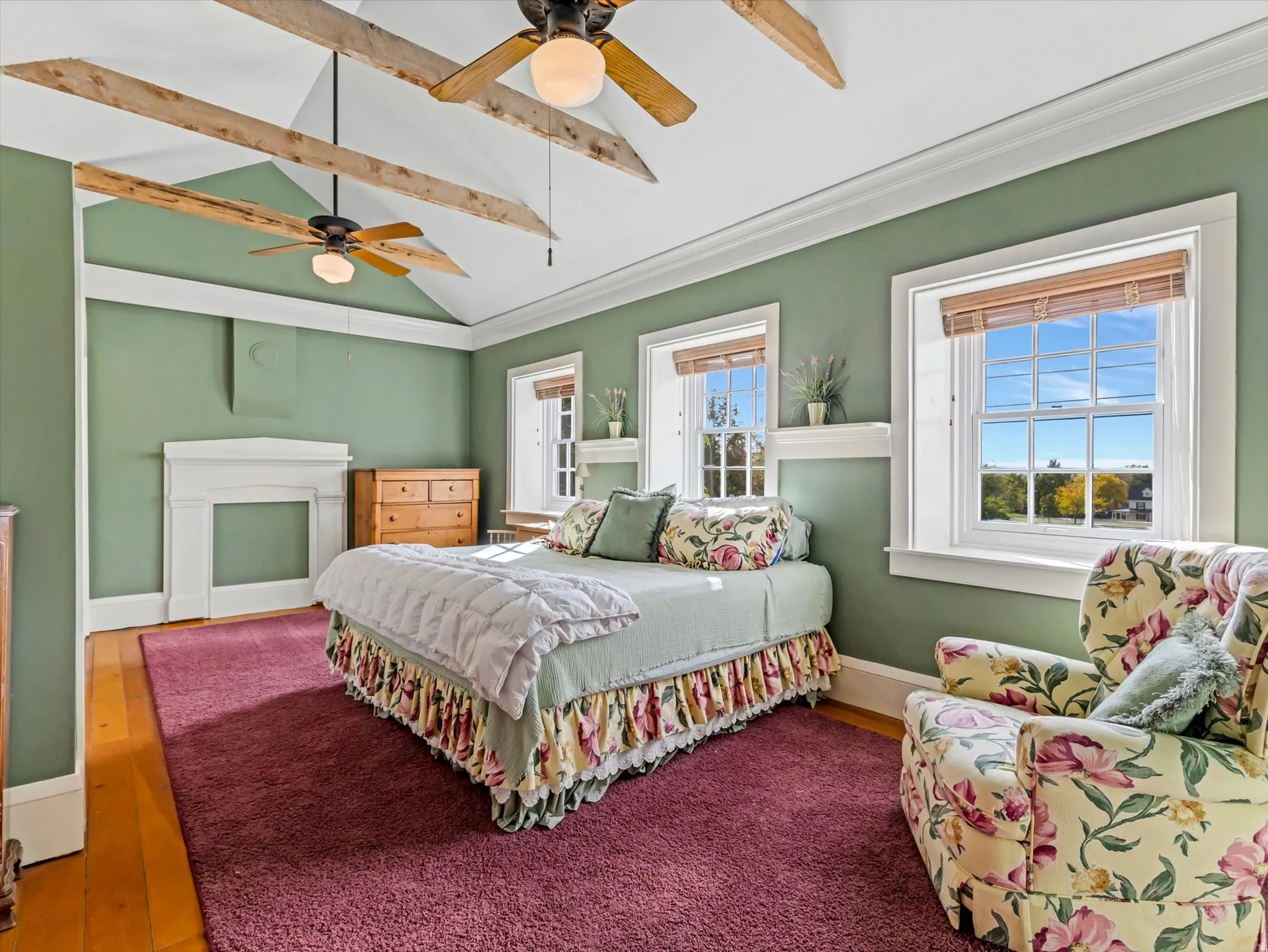 Vaulted ceiling featuring exposed wood beams and two ceiling fans