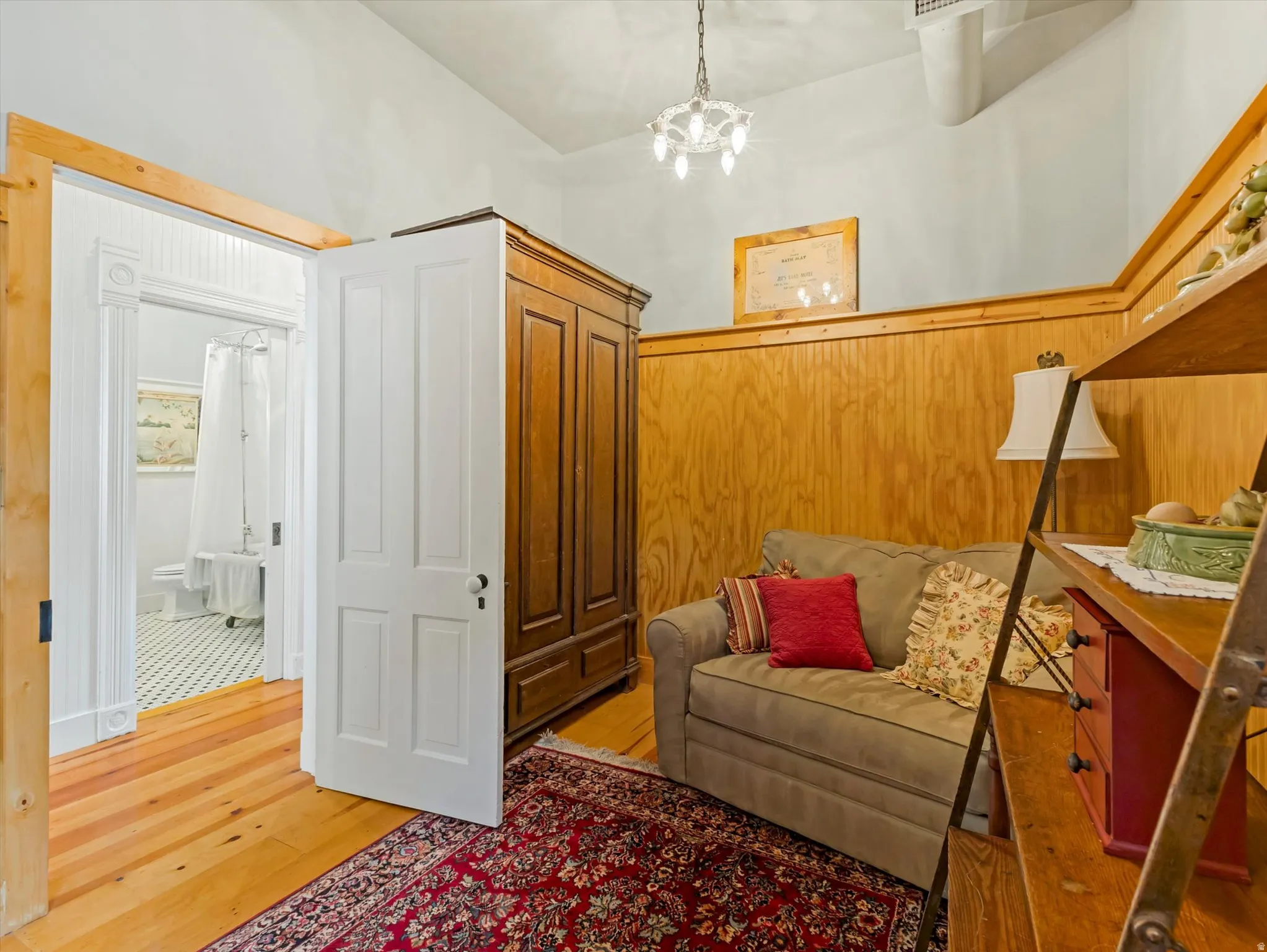 ADU Interior room featuring wood paneling, wood-finish flooring, and a decorative chandelier