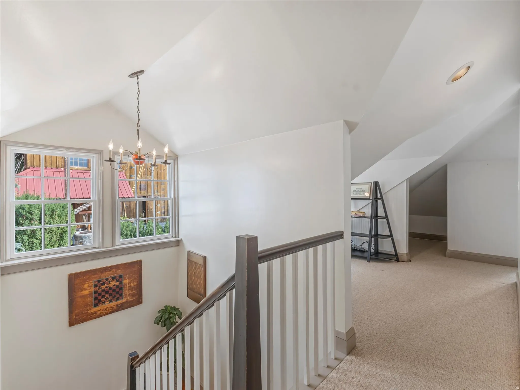 Carpeted upper hallway with vaulted ceilings and a recessed light fixture
