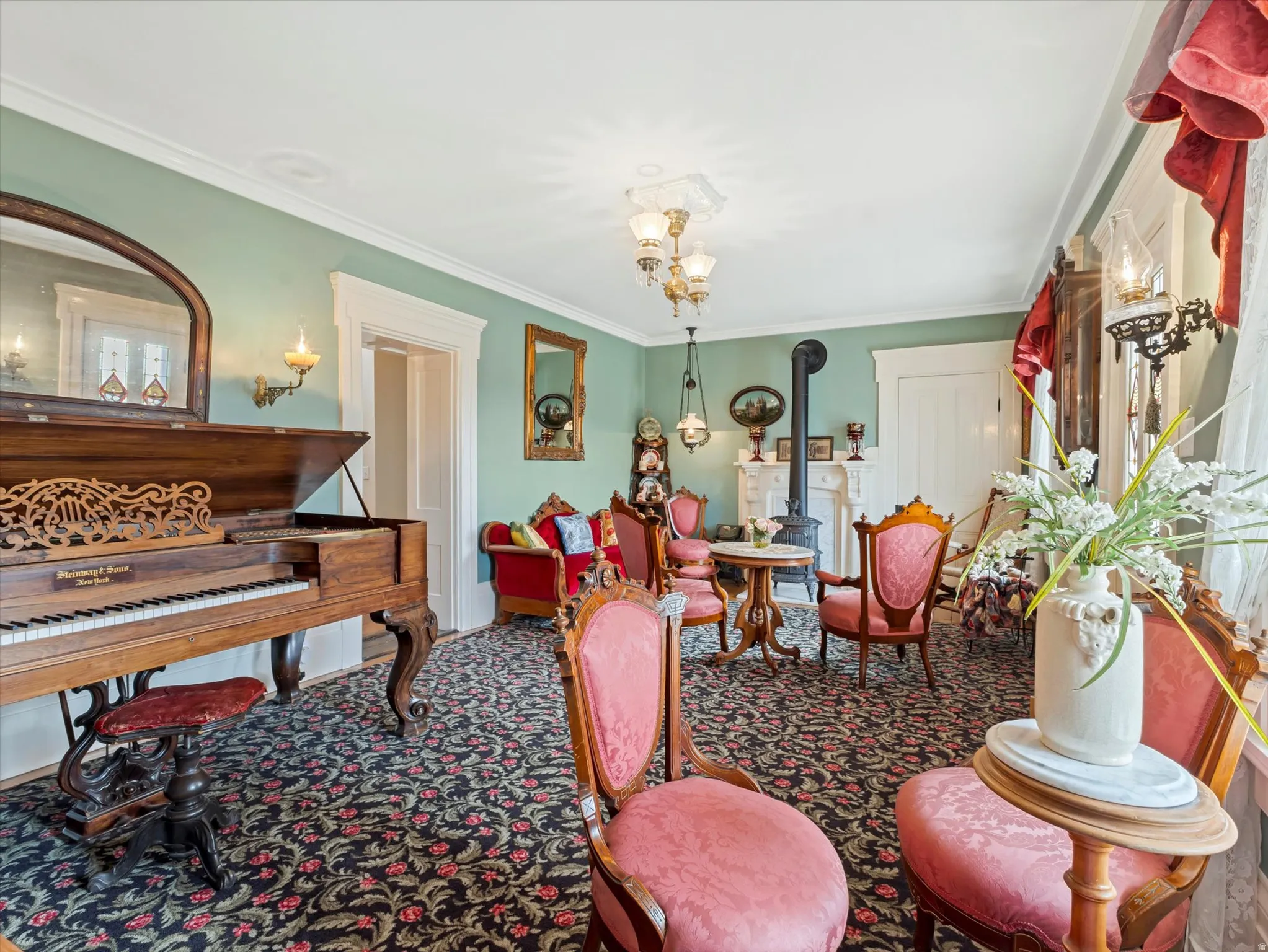 Formal living space featuring decorative crown molding, patterned carpet flooring, a wood-burning stove, and an ornate fireplace mantel