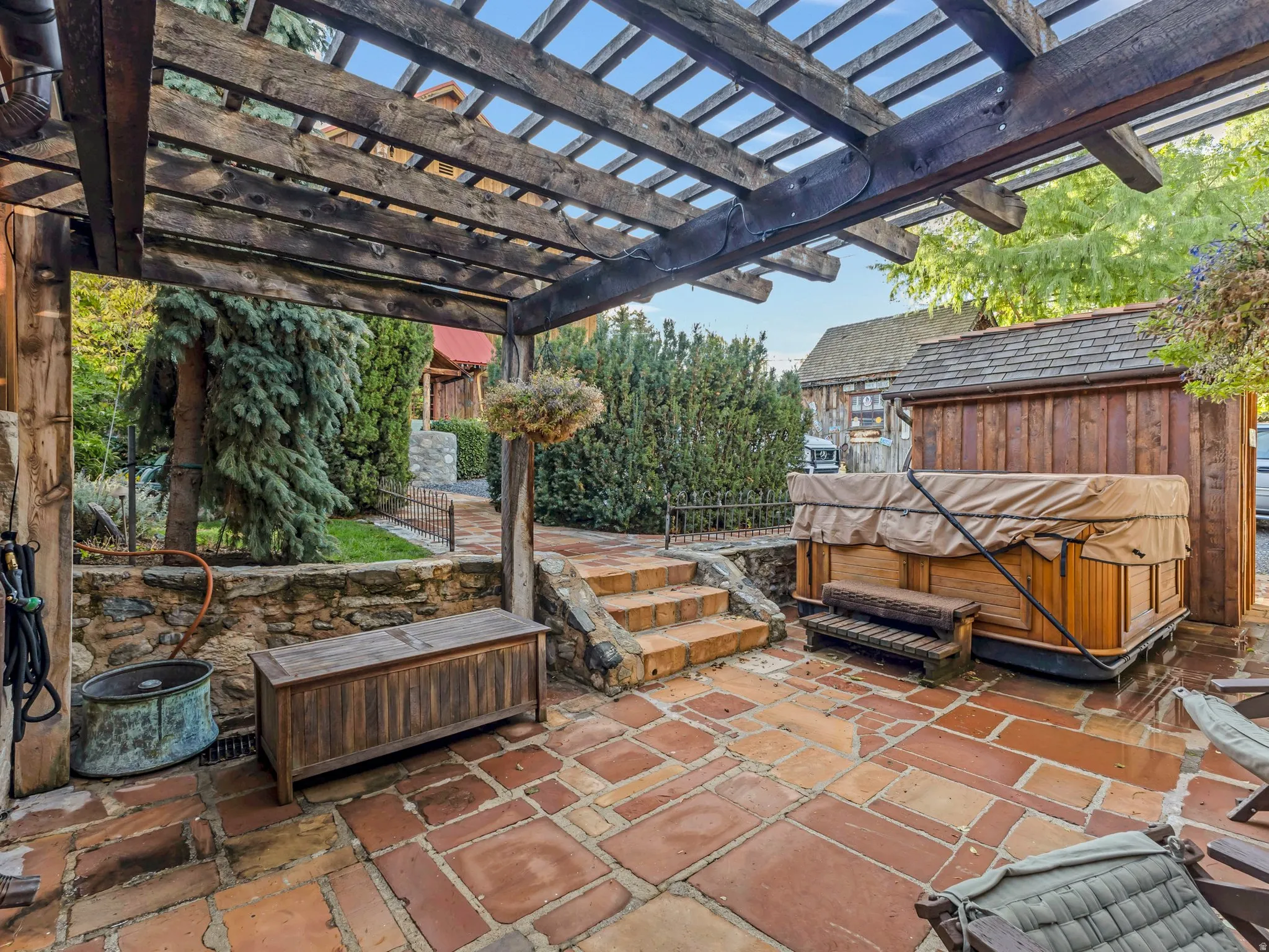 South Side Expansive outdoor patio featuring flagstone paving, a wood pergola, and a stone retaining wall